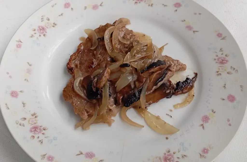 Porcion de Carne de res en salsa morena con champiñones